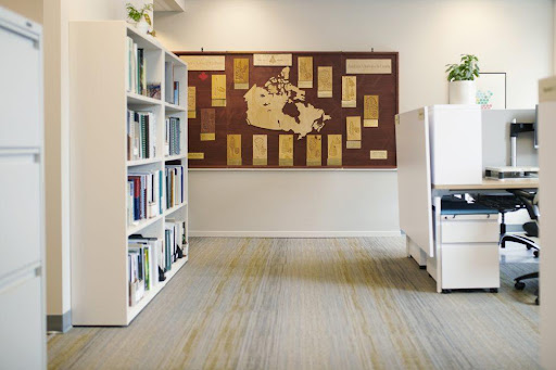 Photo of an office with bookshelves, a desk and a bulletin board with a map of Canada.