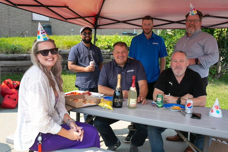 A group of colleagues pose for a photo at a barbecue.